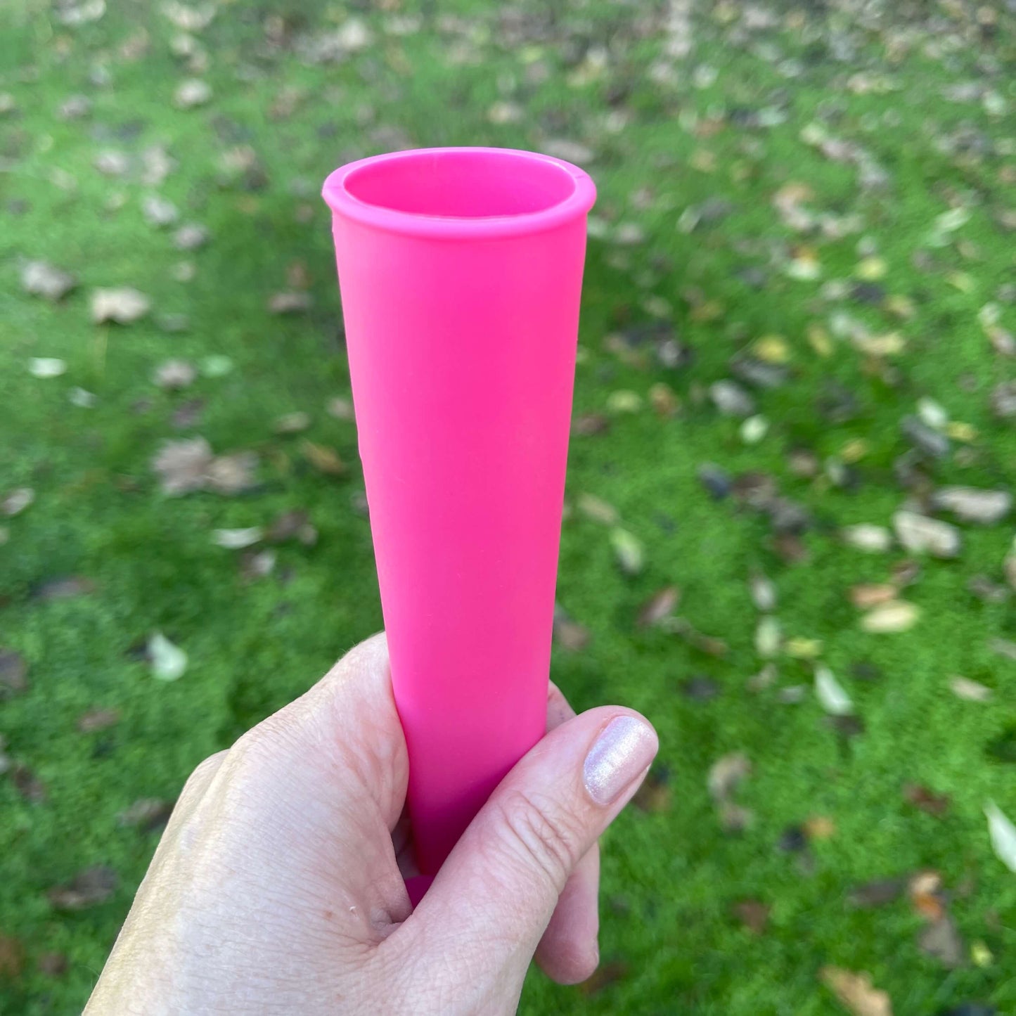 Pink silicone ice block tube being held in a womans hand.