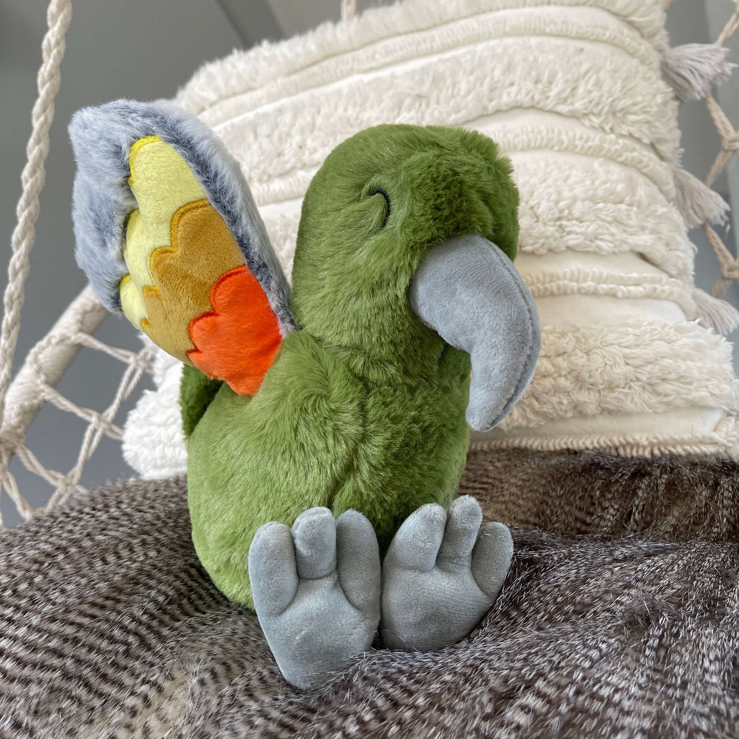 Soft toy Kea in a dusky green with orange and grey wings.