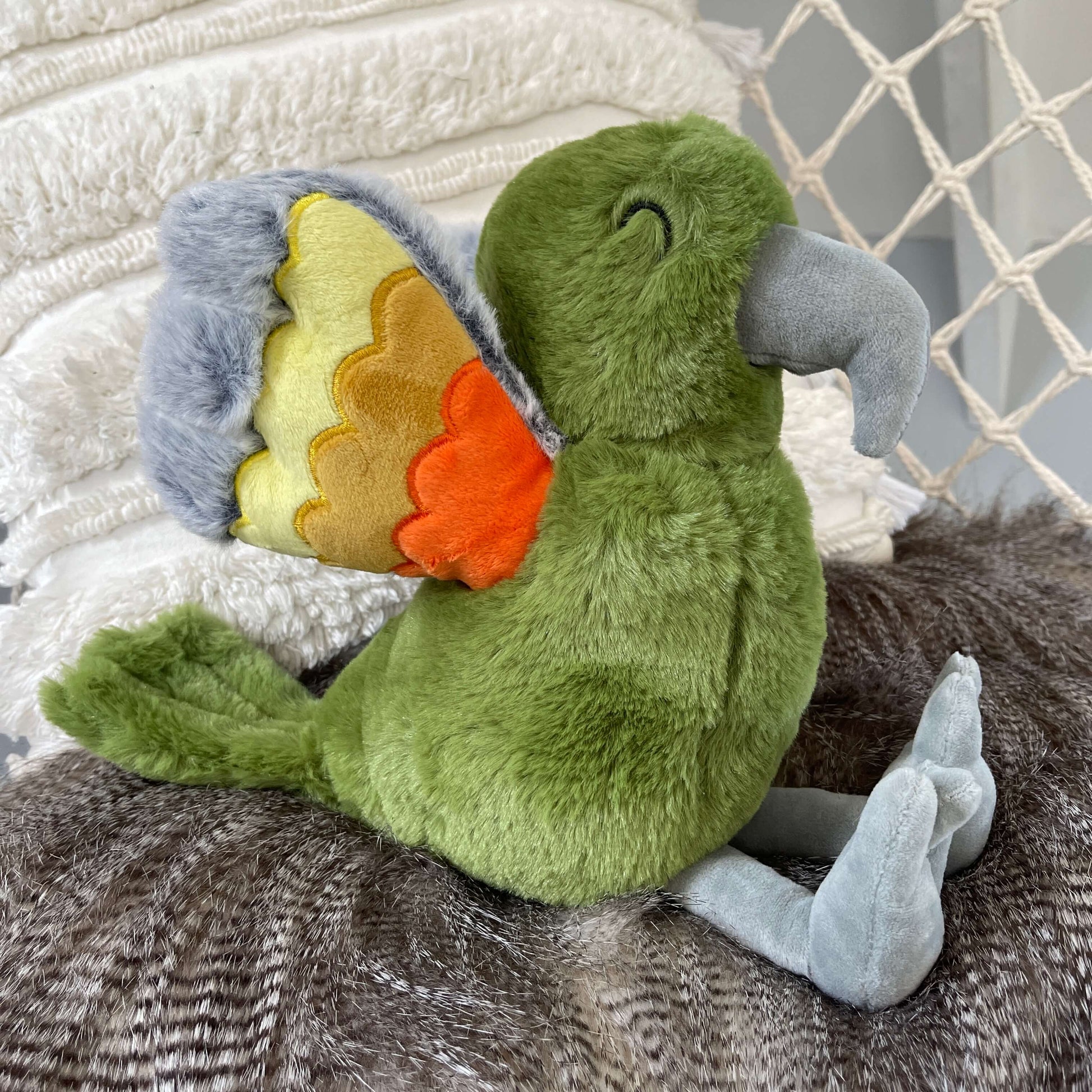 Soft toy Kea in a dusky green with orange and grey wings.