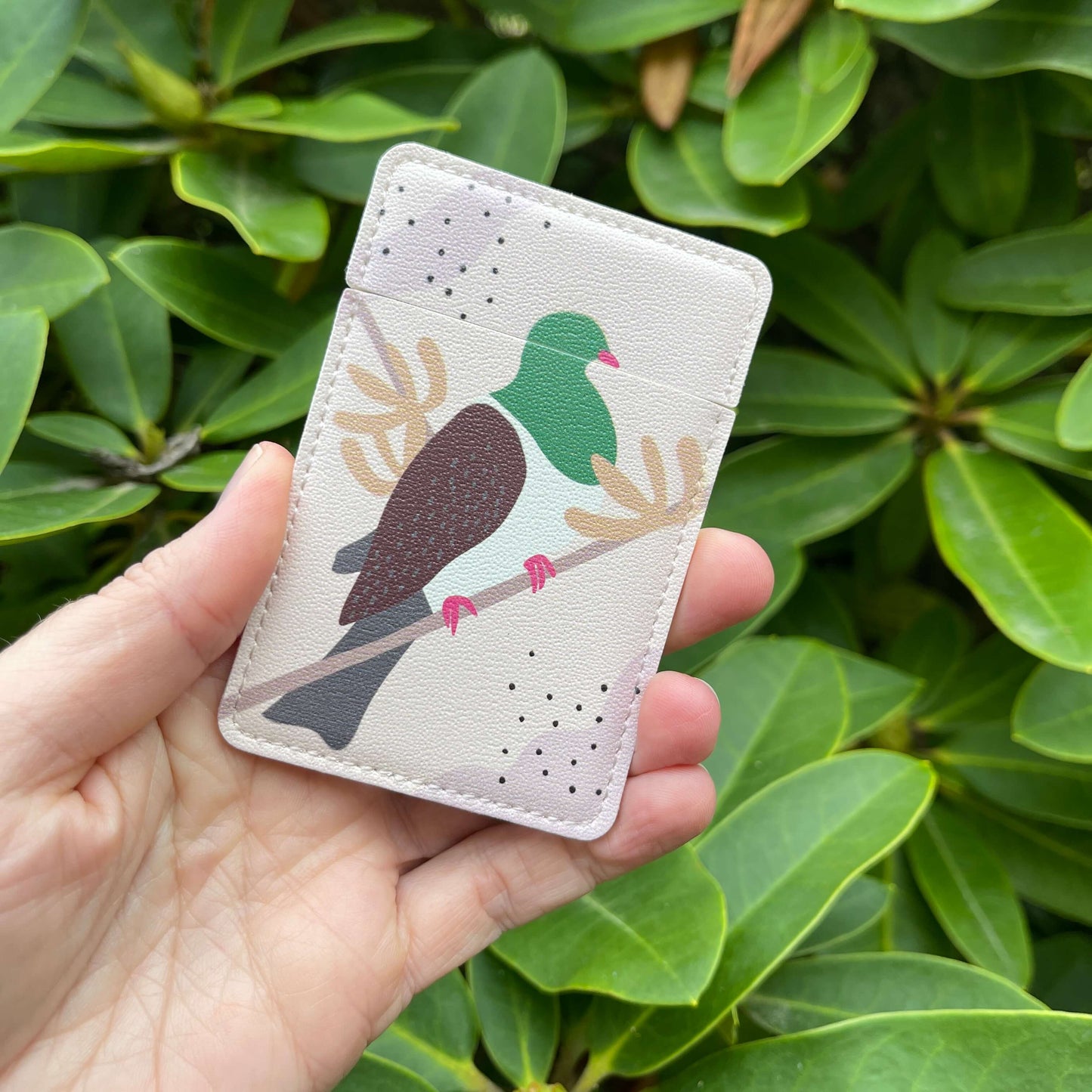 Small closed pocket mirror with a Kereru bird painted on it.