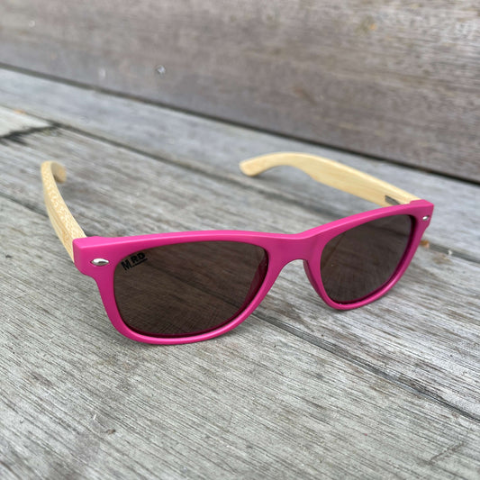 Kids sunglasses with pink frame and wooden arms.