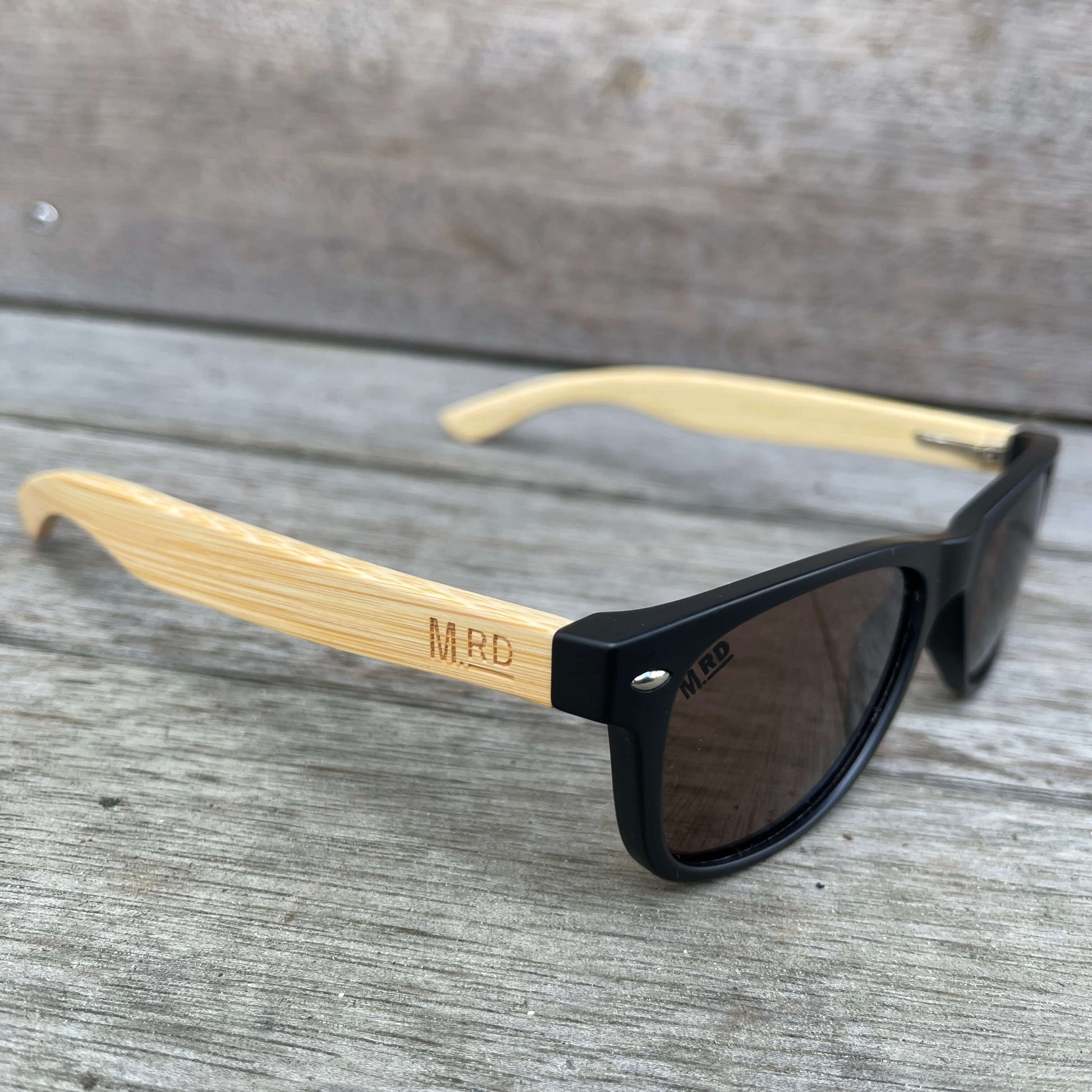Kids sunglasses with black frame and wood arms.