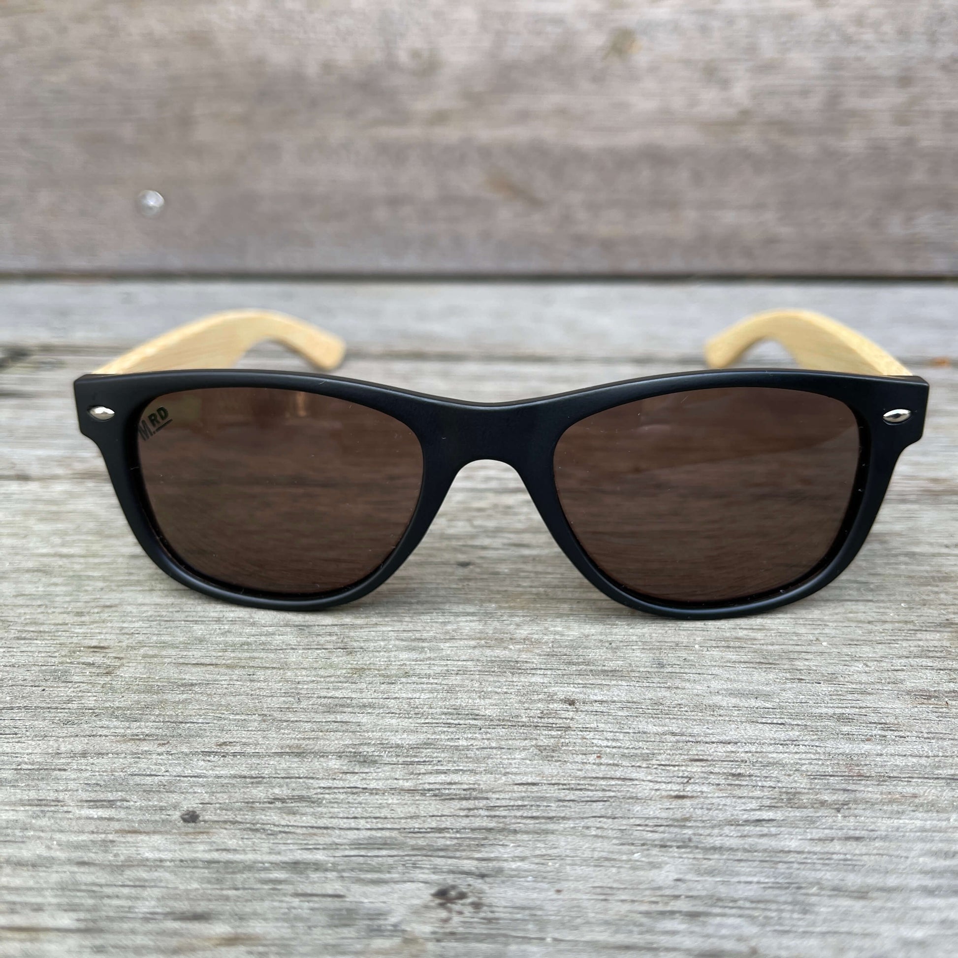 Kids sunglasses with black frame and wood arms.