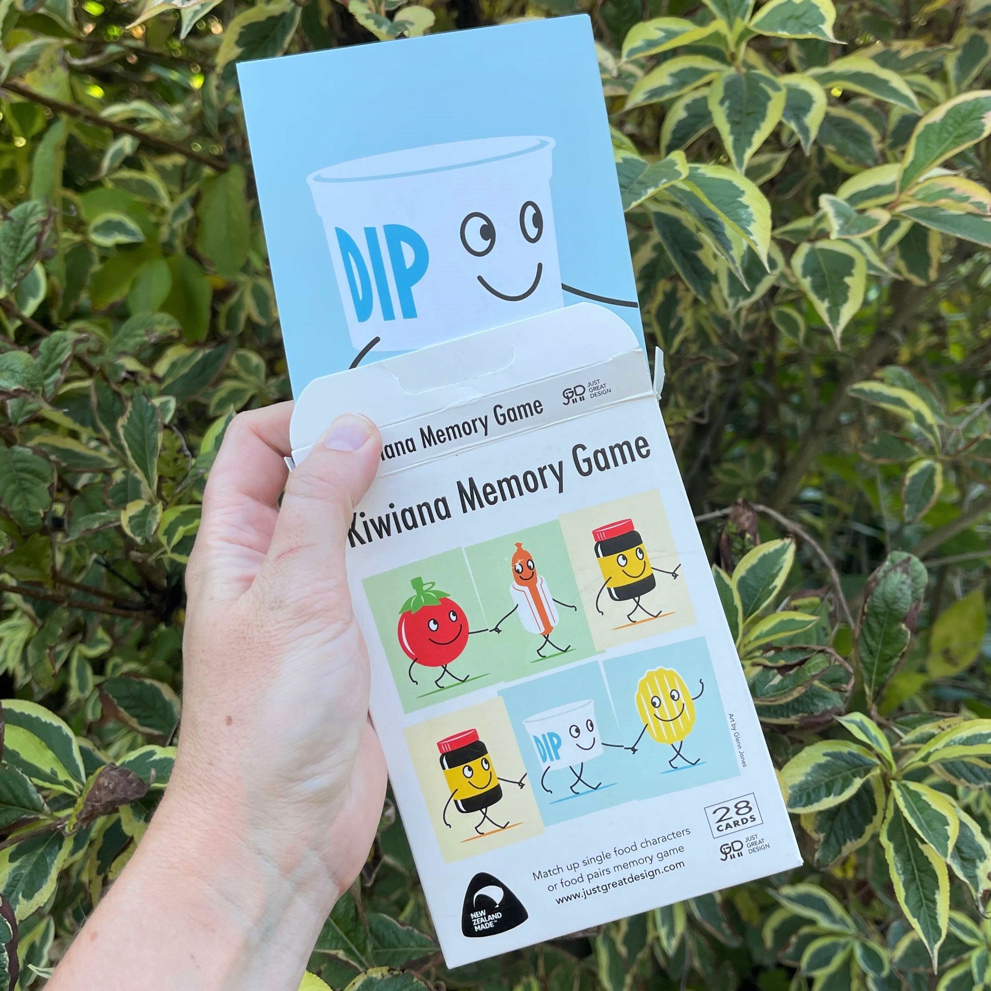 Women's hand holding cards for a New Zealand themed memory game.