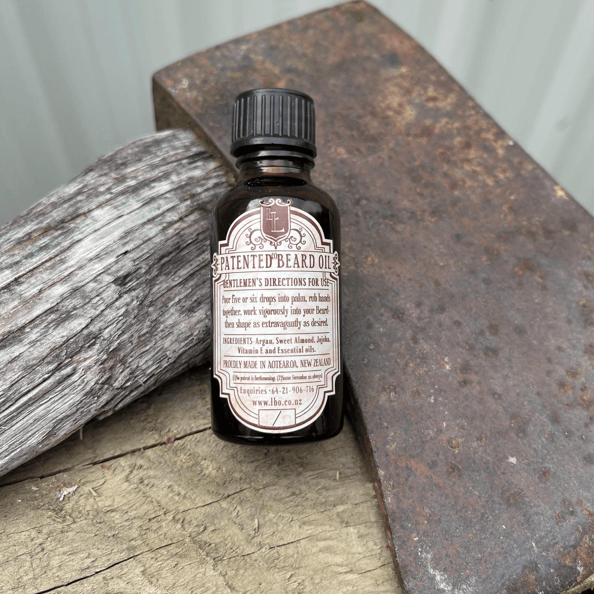 Beard oil bottle with directions for use, resting against an axe blade.