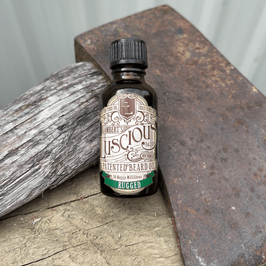 Small bottle of beard oil from Lamberts Luscious resting against an axe blade.