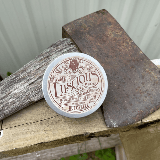 Metal tin sitting next to an axe with shaving soap inside.
