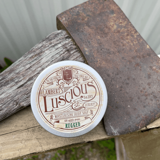 Metal tin sitting next to an axe with shaving soap inside.