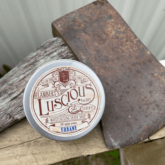 Metal tin sitting next to an axe with shaving soap inside.