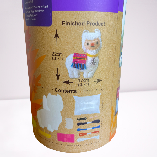 close up of the contents in a Childrens llama sewing kit in a cardboard tube.