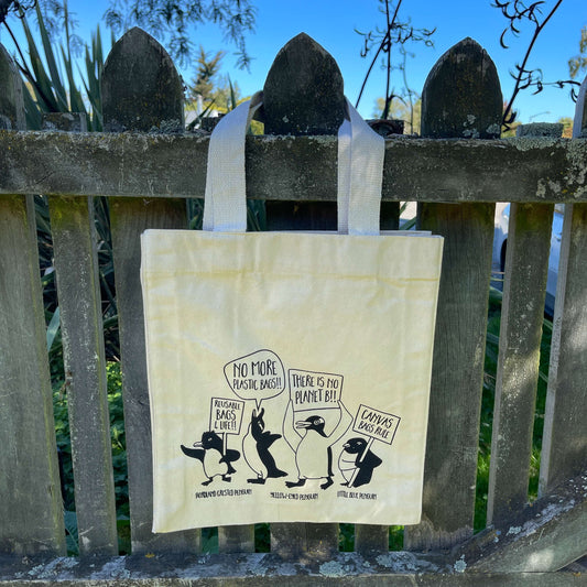 Canvas tote bag with penguins protesting about saving the planet.