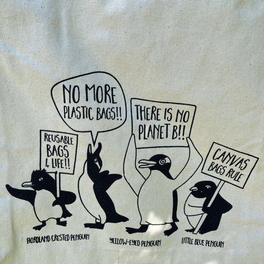 Canvas tote bag with penguins protesting about saving the planet.