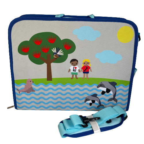 Kids satchel bag with pohutukawa tree, fantail, seal, hectors dolphins and 2 children painted on it. Additional bag strap sitting beside the bag.