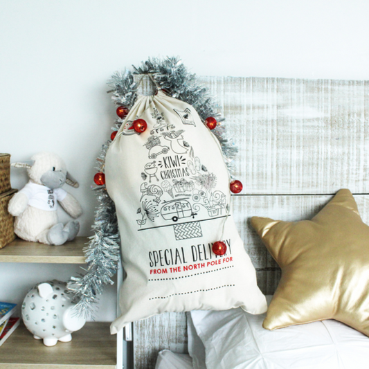 Childs bedroom with a Christmas Sack and decorations hanging from the corner of the beds headboard.