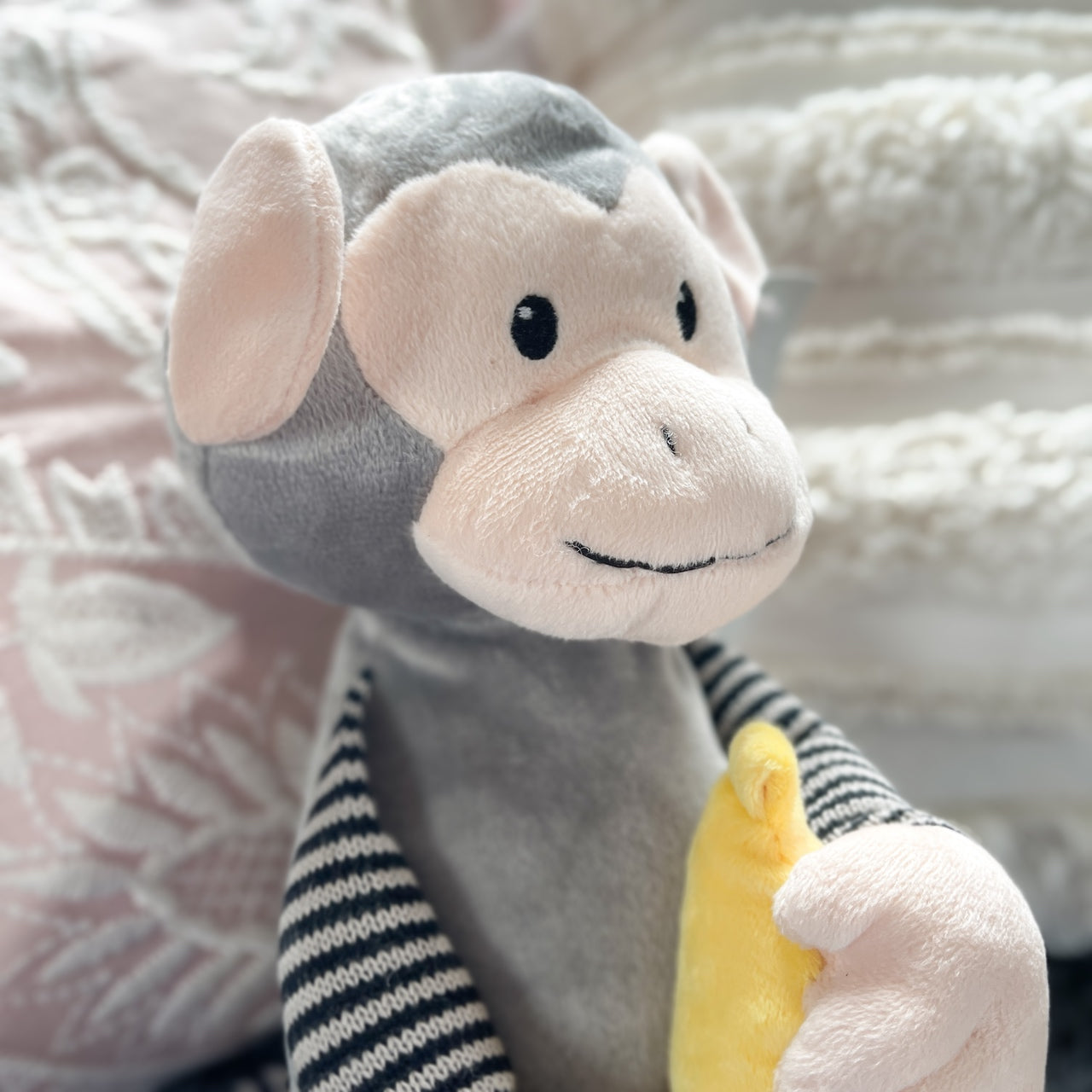 Soft toy monkey holding a banana.