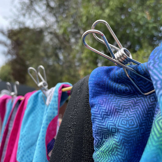 Stainless steel clothes pegs holding washing on a line.