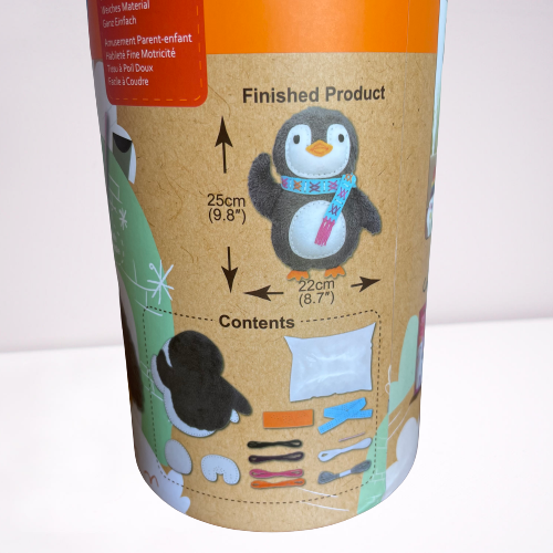 Close up of the contents in a Childrens penguin sewing kit in a cardboard tube.