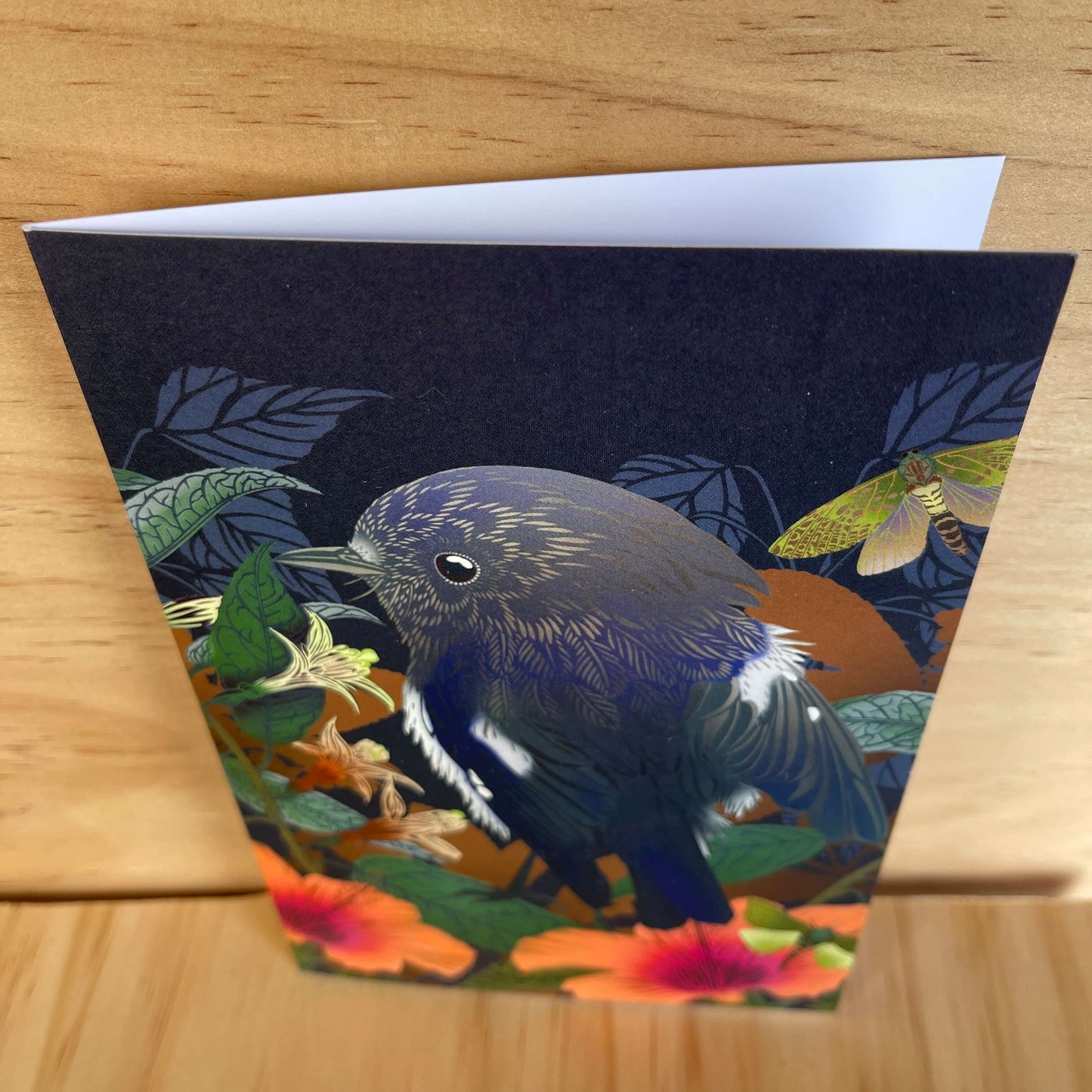Greeting card by designer Flox featuring a Miromiro bird and Puriri Moth amongst flowers.