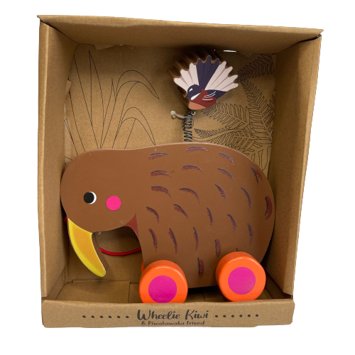 Pull-along wooden Kiwi bird toy with a fantail bird on a spring attached to the Kiwis back sitting in a box with fern printing in the background.