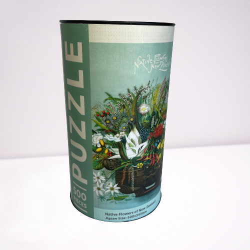 Cardboard tube with a jigsaw puzzle inside featuring artwork of native New Zealand flowers.