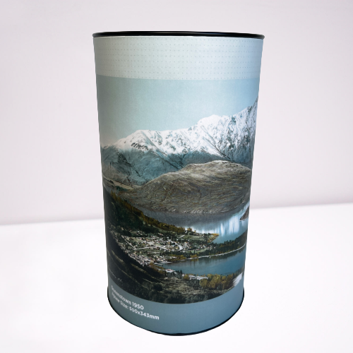 Cardboard tube with a jigsaw puzzle inside featuring artwork of the Queenstown.