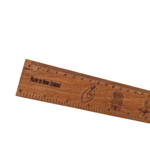 Wooden rimu ruler with Maori designs engraved into it.