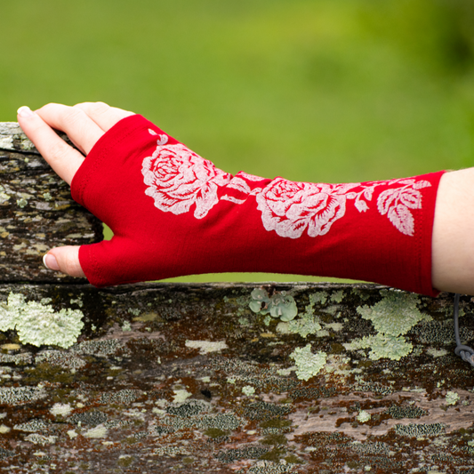 Fingerless merino gloves in red with white rose print.