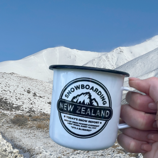 Enamel mug with snowboarding NZ on it and snowy mountains in the background. 