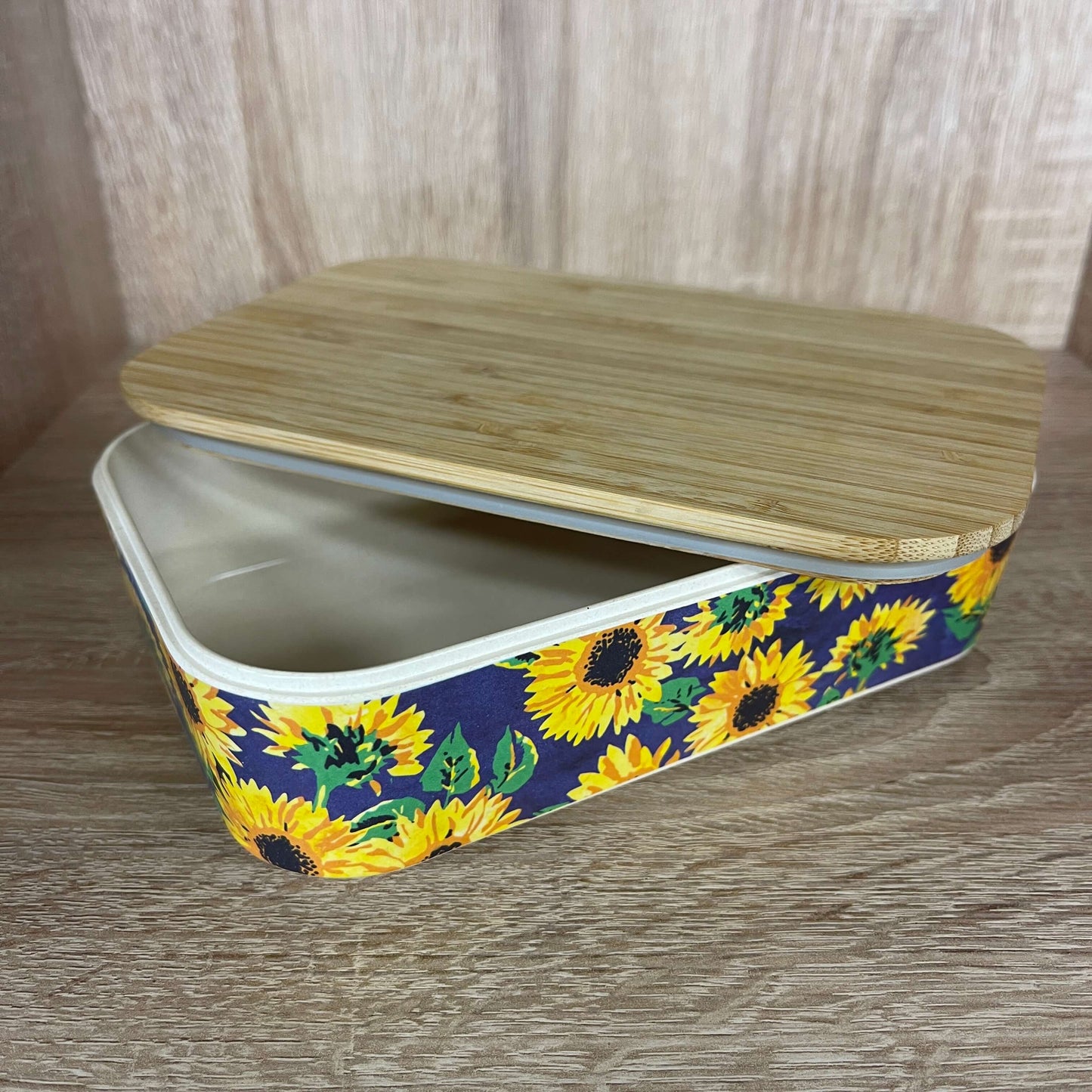 Bamboo lunchbox with sunflower print and blue silicone band.