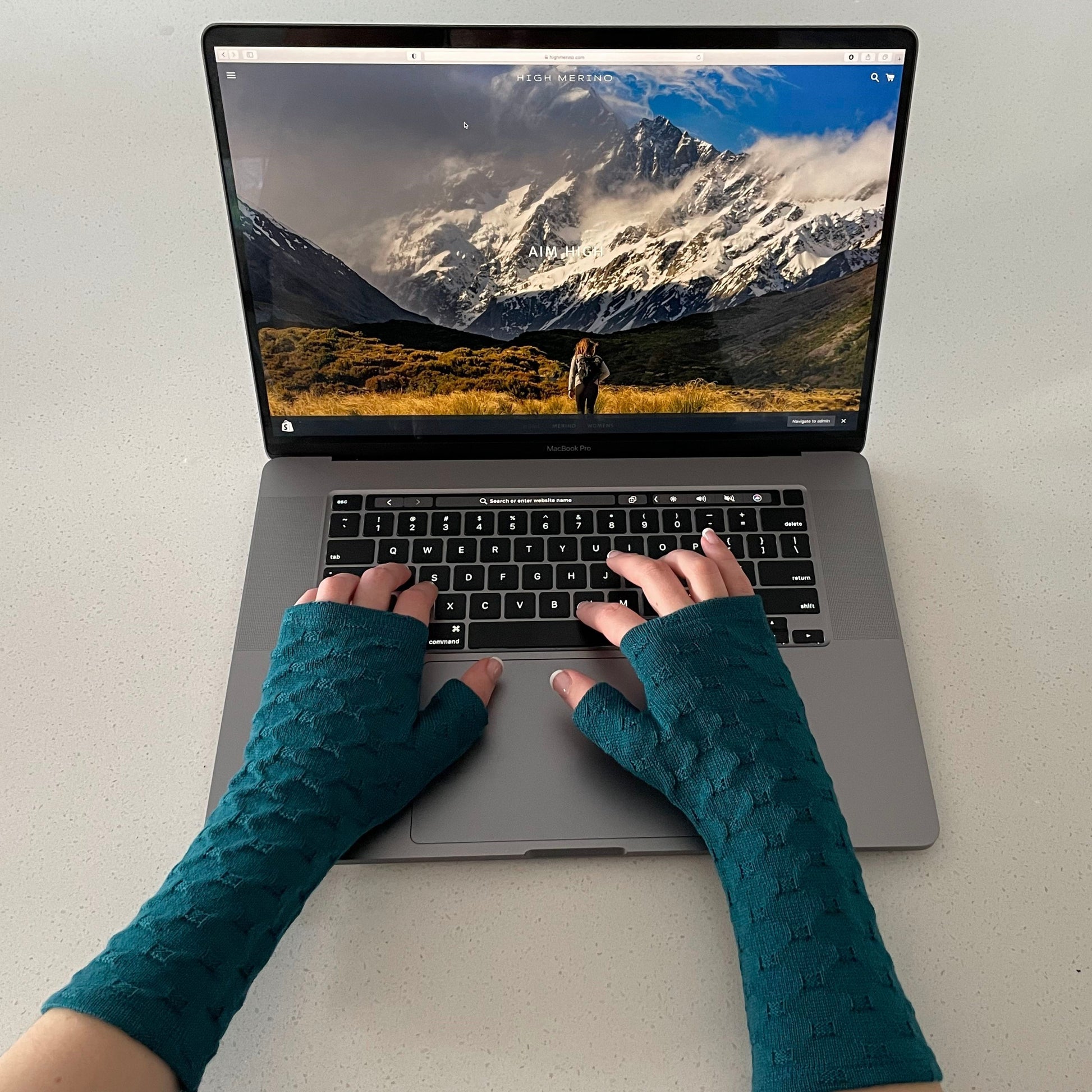 Fingerless merino gloves in teal textured knit.