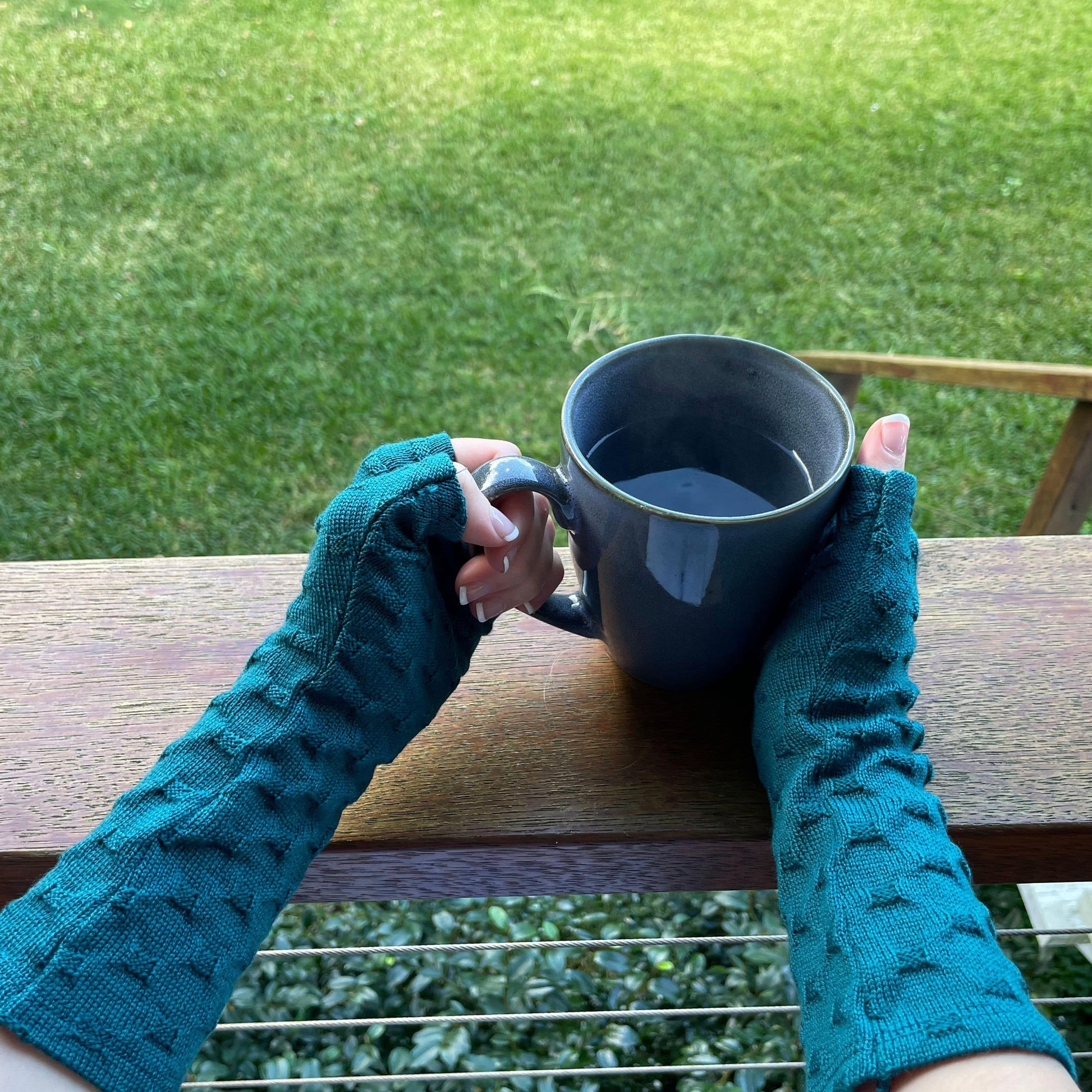 Fingerless merino gloves in teal textured knit.