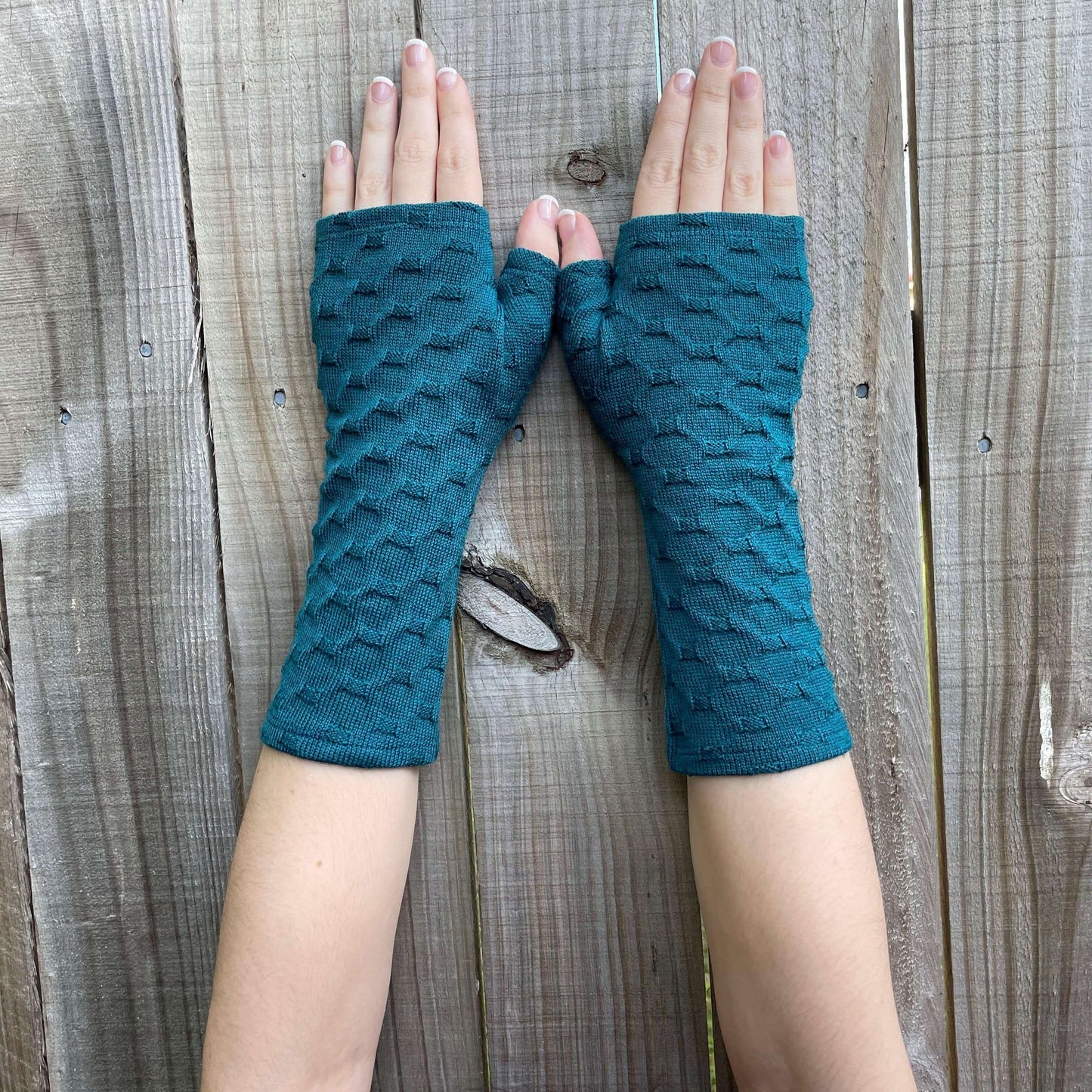 Fingerless merino gloves in teal textured knit.
