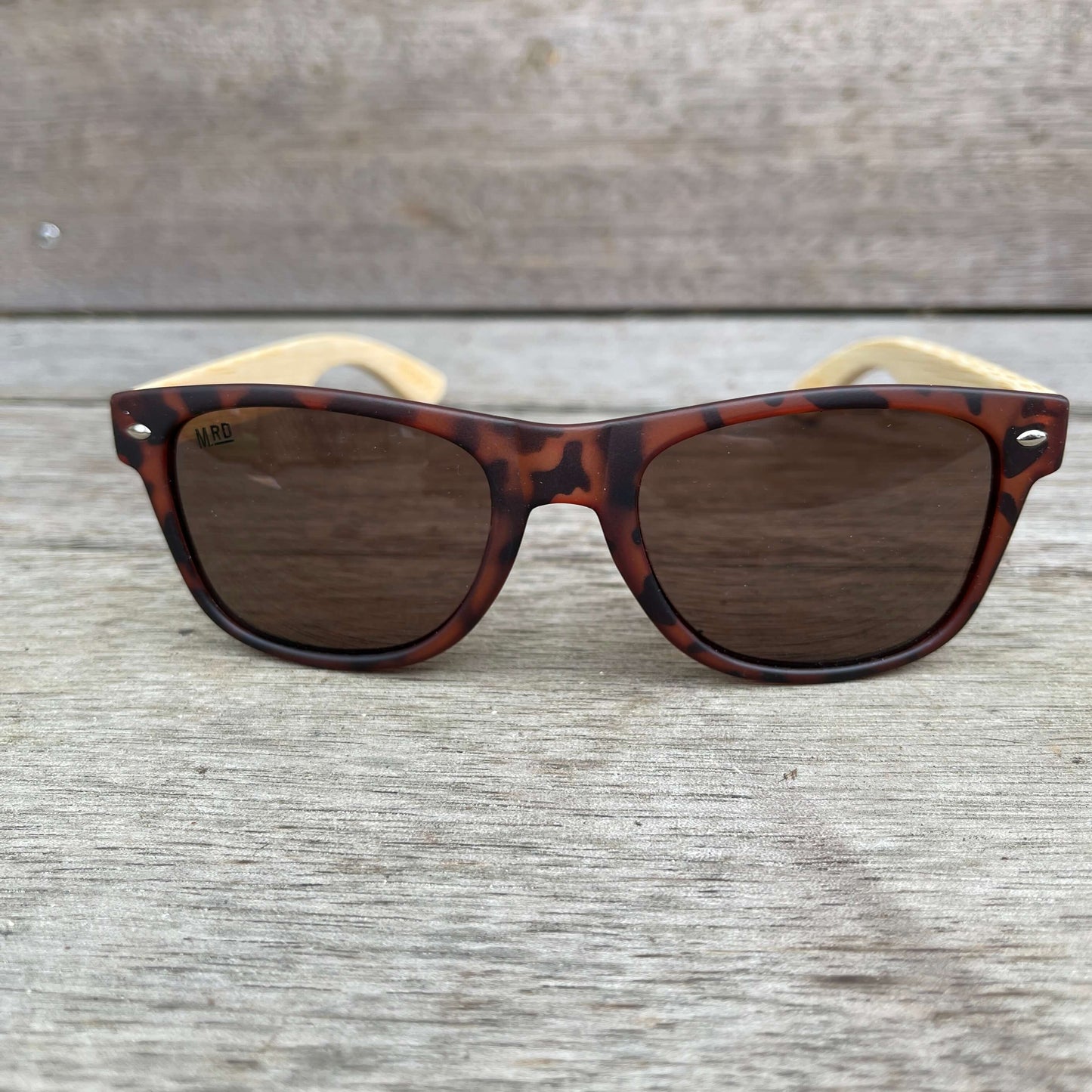 Sunglasses with brown tortoiseshell frames and wooden arms.