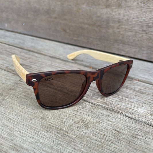 Sunglasses with brown tortoiseshell frames and wooden arms.