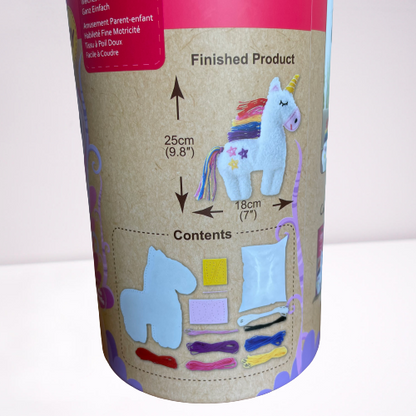 Close up of whats included in Childrens unicorn sewing kit in a cardboard tube.