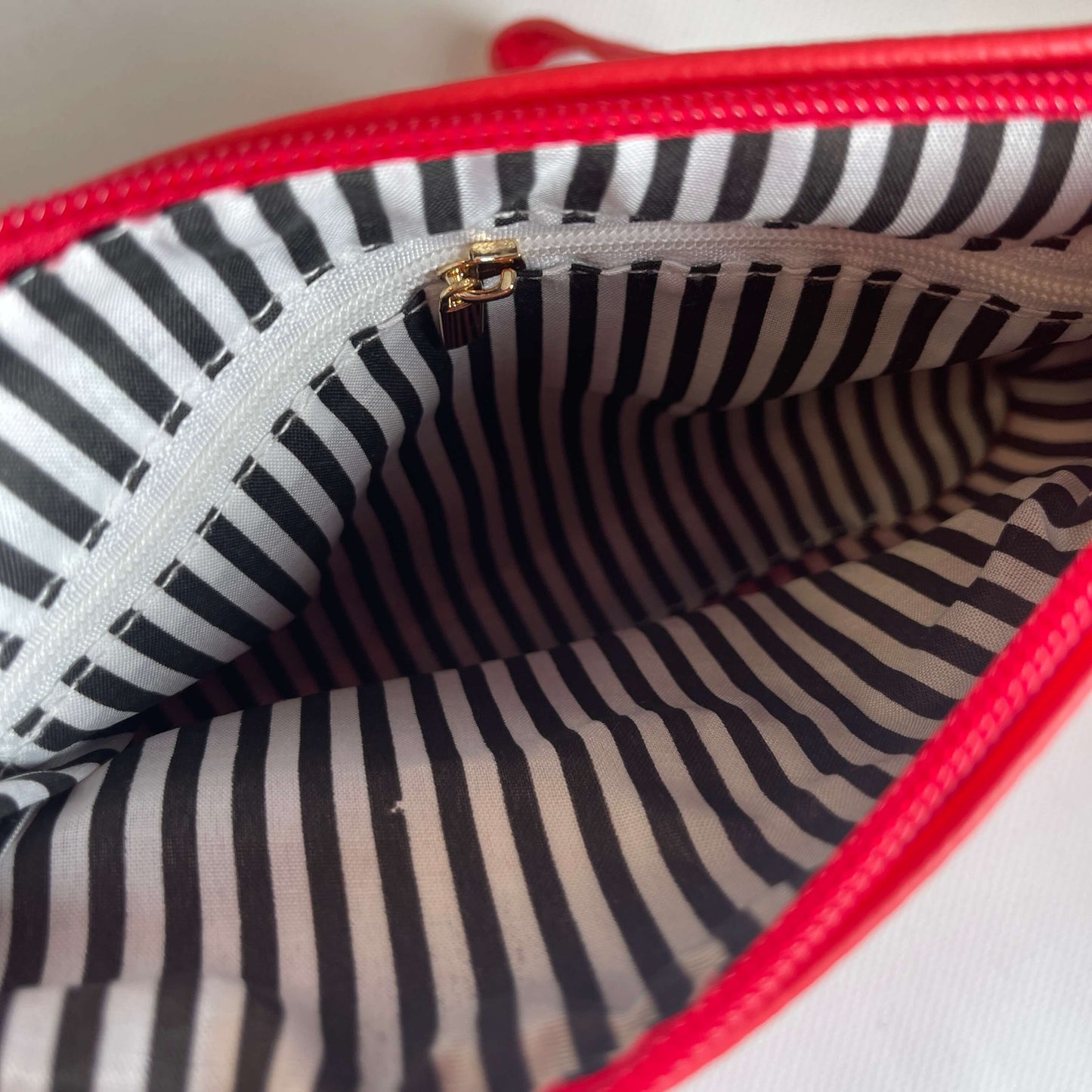Inside lining of a red clutch bag.