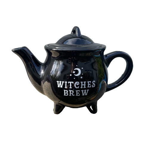 Black teapot with Witches Brew written on it in white.