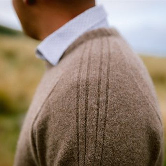 Close up of shoulder detail on a natural brown woolen jersey.