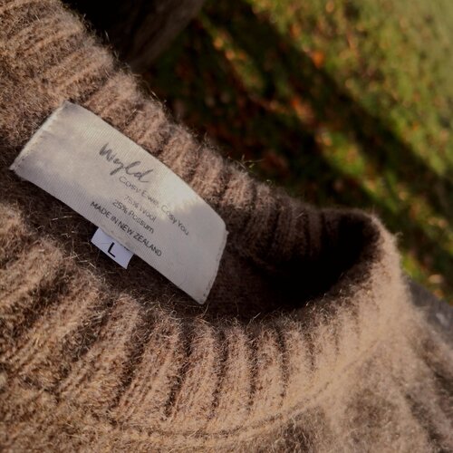 Close up of neckline from a natural brown woolen jersey.