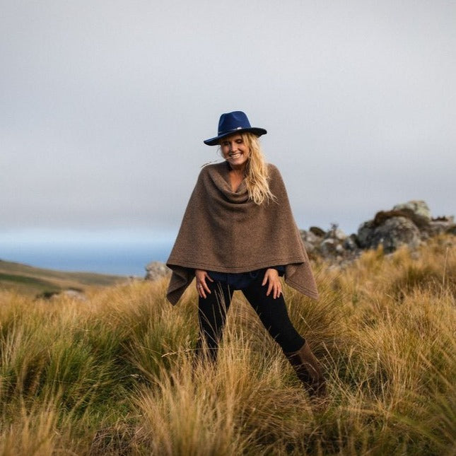 Woman wearing a brown wool poncho.