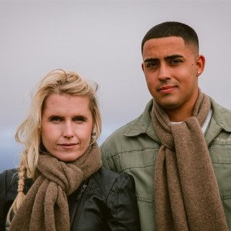 Couple wearing natural brown woolen scarves from Wyld.