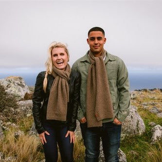 Couple wearing natural brown woolen scarves from Wyld.
