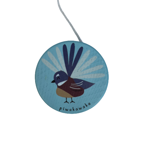A sky blue wooden yoyo with a Fantail bird painted on it.