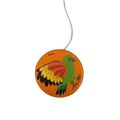 A bright orange wooden yoyo with a Kea bird painted on it.