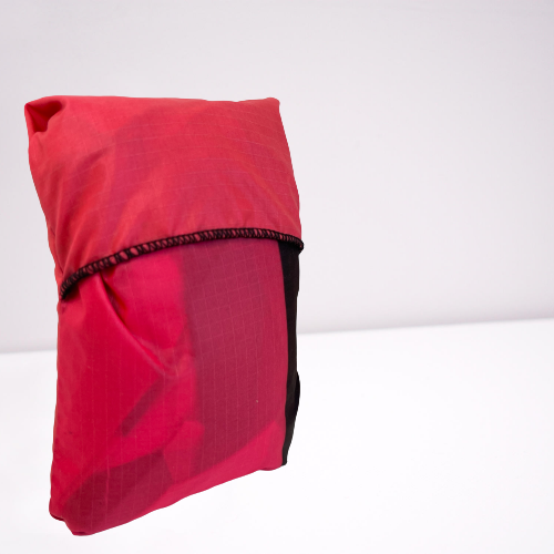 Bright pink folded up tote bag made from parachutes.