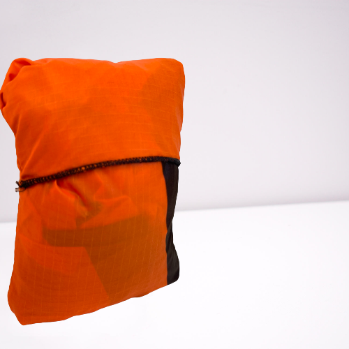 Bright orange folded up tote bag made from parachutes.