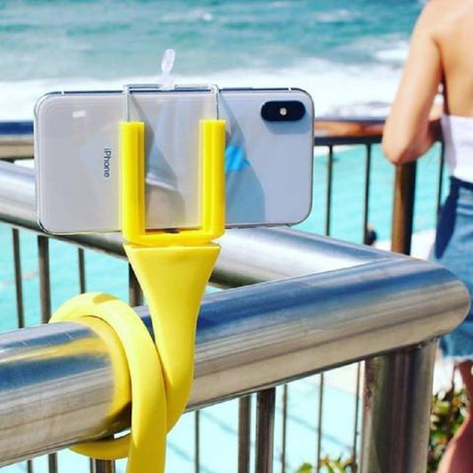 Yellow flexi selfie stick wrapped around a pole.